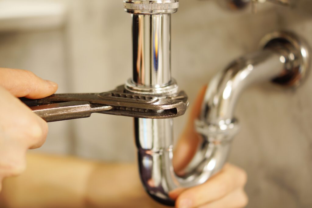 Plumber using a wrench to carry out a pipe repair