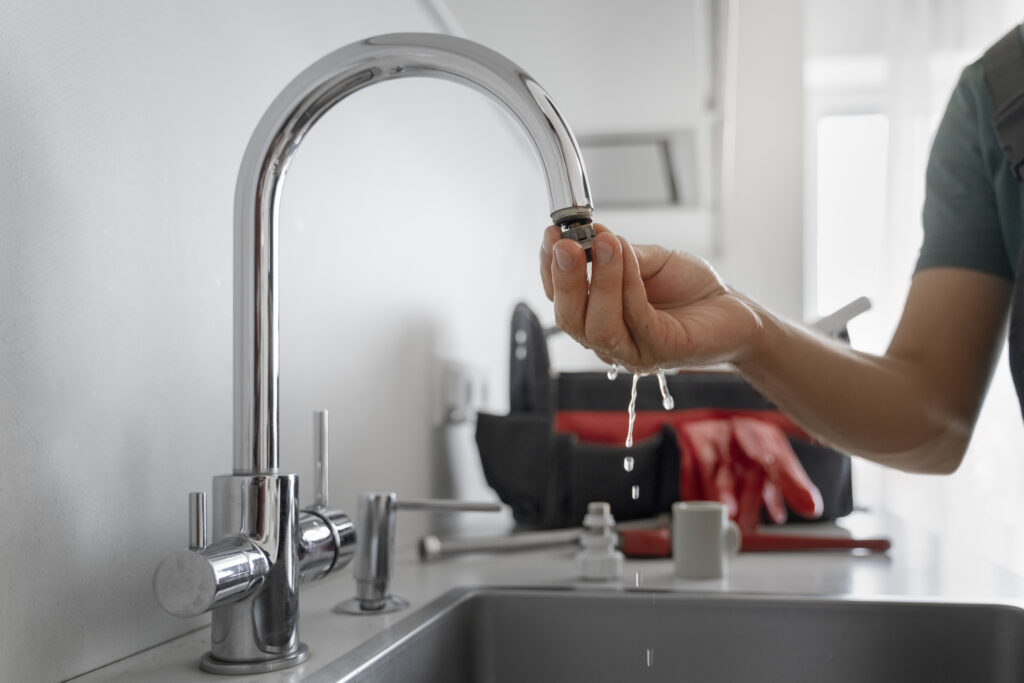 Plumber testing a kitchen tap after a plumbing repair